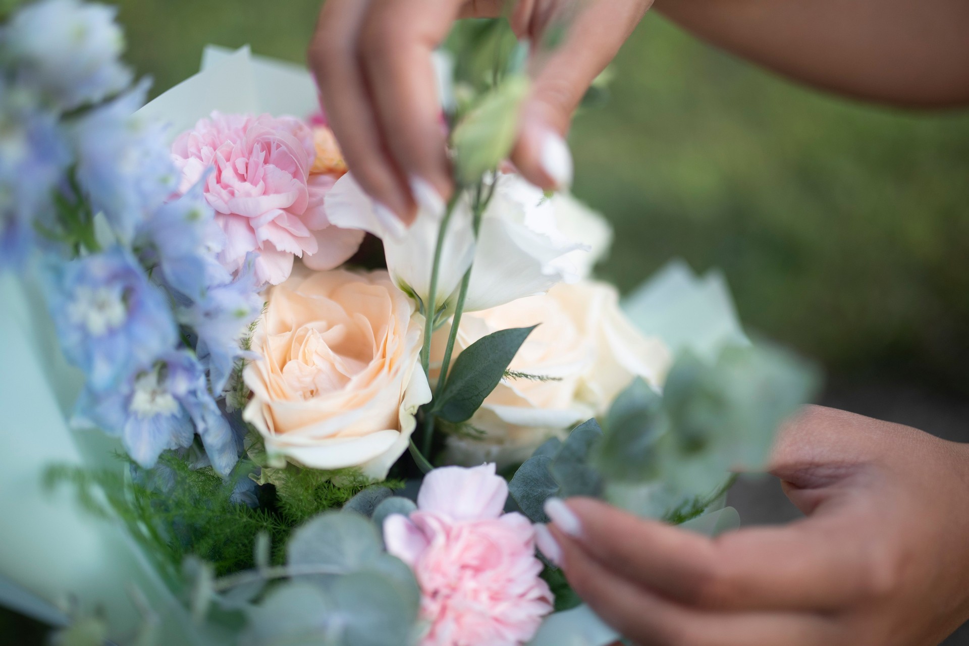 Close-up of female hands arranging a bouquet of flowers